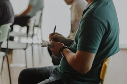 Ein Mensch macht sich sitzend Notizen